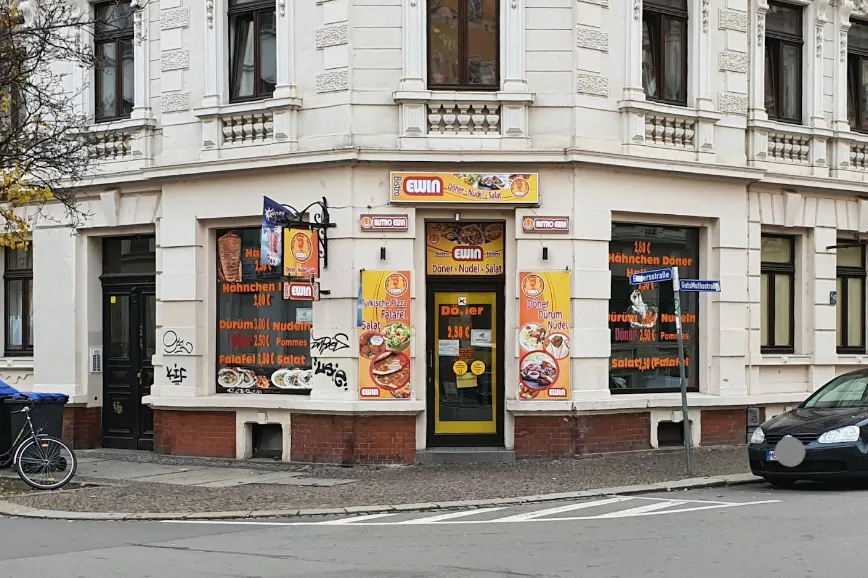 Beispielfoto einer Ladenfront: Eckhaus mit gelb-roten Schildern