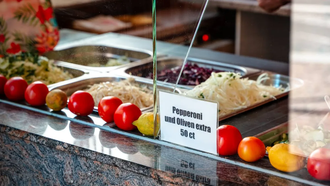 Die Salattheke mit frischem Gemüse hinter der Scheibe